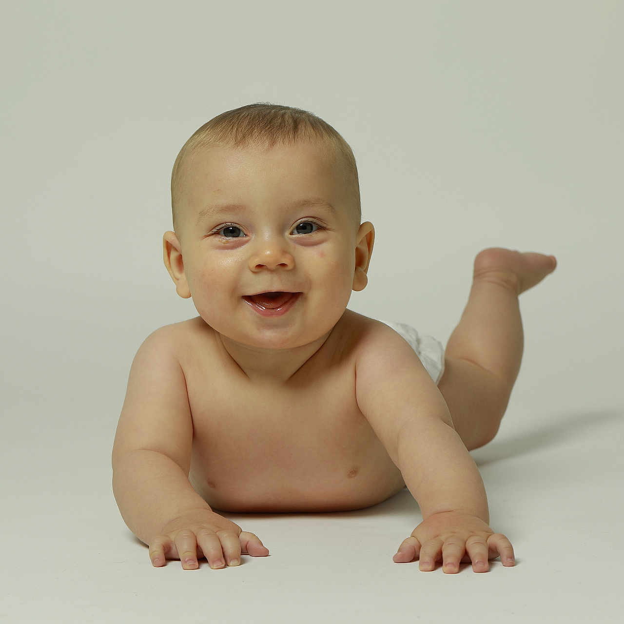 Mylan participe au concours pour gagner de l'argent avec cette photo : arms, baby, bare_skin, child, cute, diaper, expression, face, happy, infant, legs, light_background, lying_down, playful, portrait, skin, smiling, studio, toddler, young