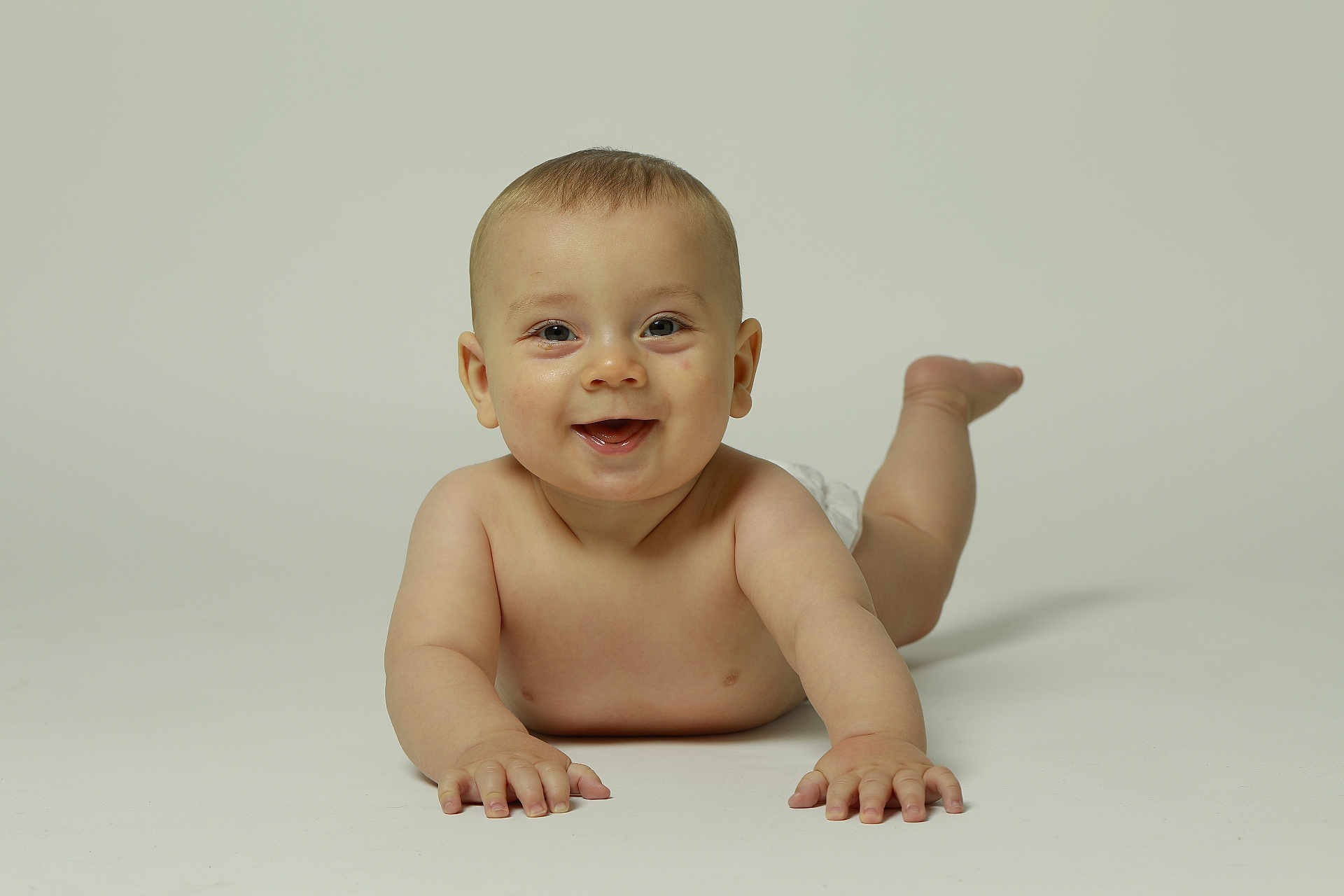 Mylan participe au concours pour gagner de l'argent avec cette photo : baby, infant, smiling, lying_down, bare_skin, diaper, happy, child, cute, toddler, playful, arms, legs, face, portrait, studio, light_background, skin, young, expression