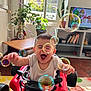 toddler, child, toy_car, bubbles, indoor, living_room, smiling, happy, playful, plant, window, furniture, television, bookshelf, floor_rug, cactus, joyful, person, home, playtime