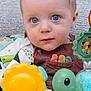 Kody is registered to the contest to win money with this photo: baby, blue_eyes, child, closeup, clothing, colorful, cute, face, green_toy, indoors, infant, lion_toy, looking_at_camera, overalls, playtime, portrait, soft_background, toy, turtle_toy, yellow_toy