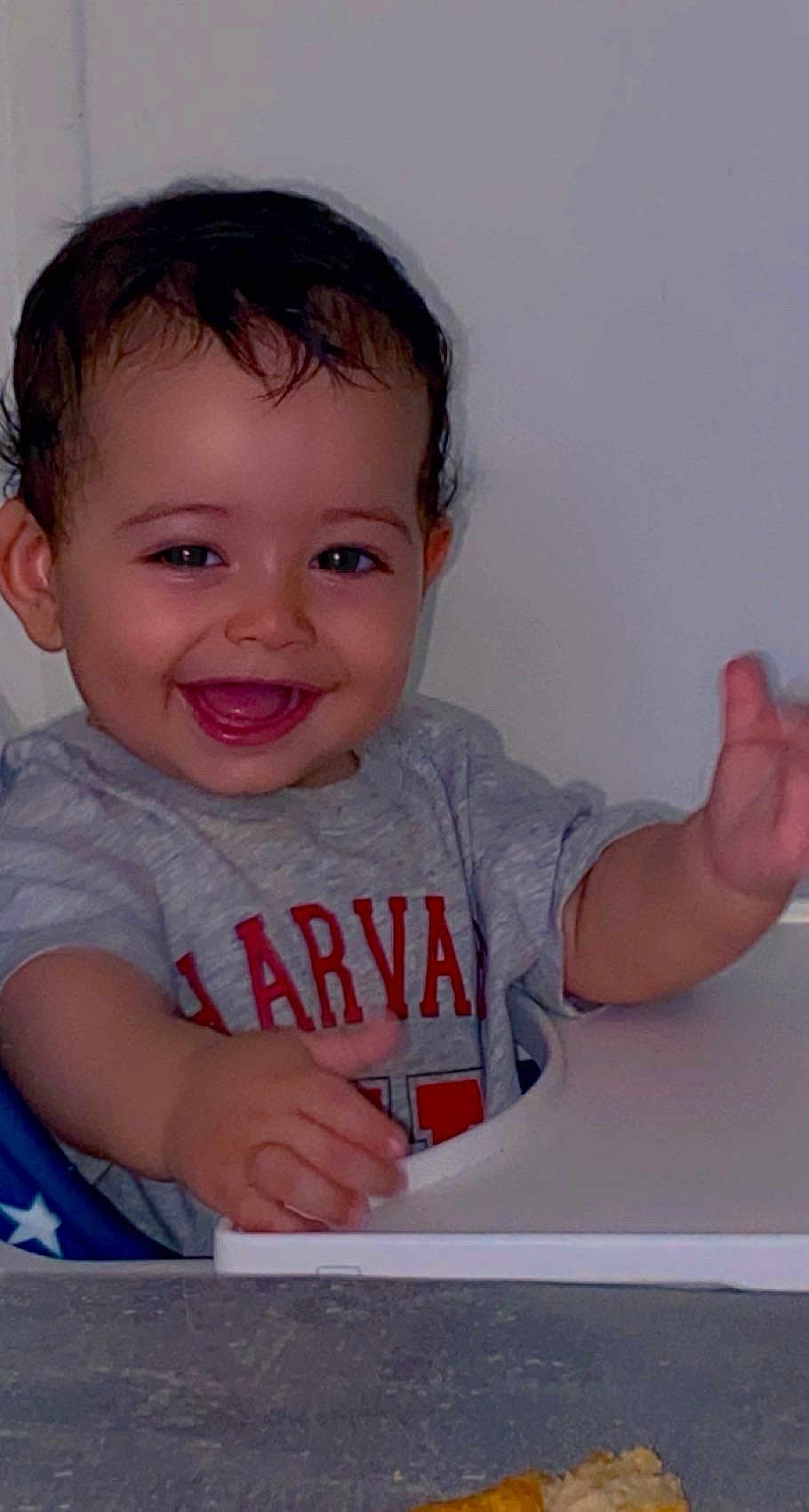 Loai participe au concours pour gagner de l'argent avec cette photo : toddler, child, smiling, happy, high_chair, table, food, shirt, harvard, face, person, indoor, cute, baby, hand, expression, sitting, young, clothing, playful