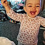 toddler, child, smiling, happy, pajamas, floral_pattern, indoor, carpet, toy, clutter, person, face, cute, baby, standing, home, living_room, furniture, playful, expression