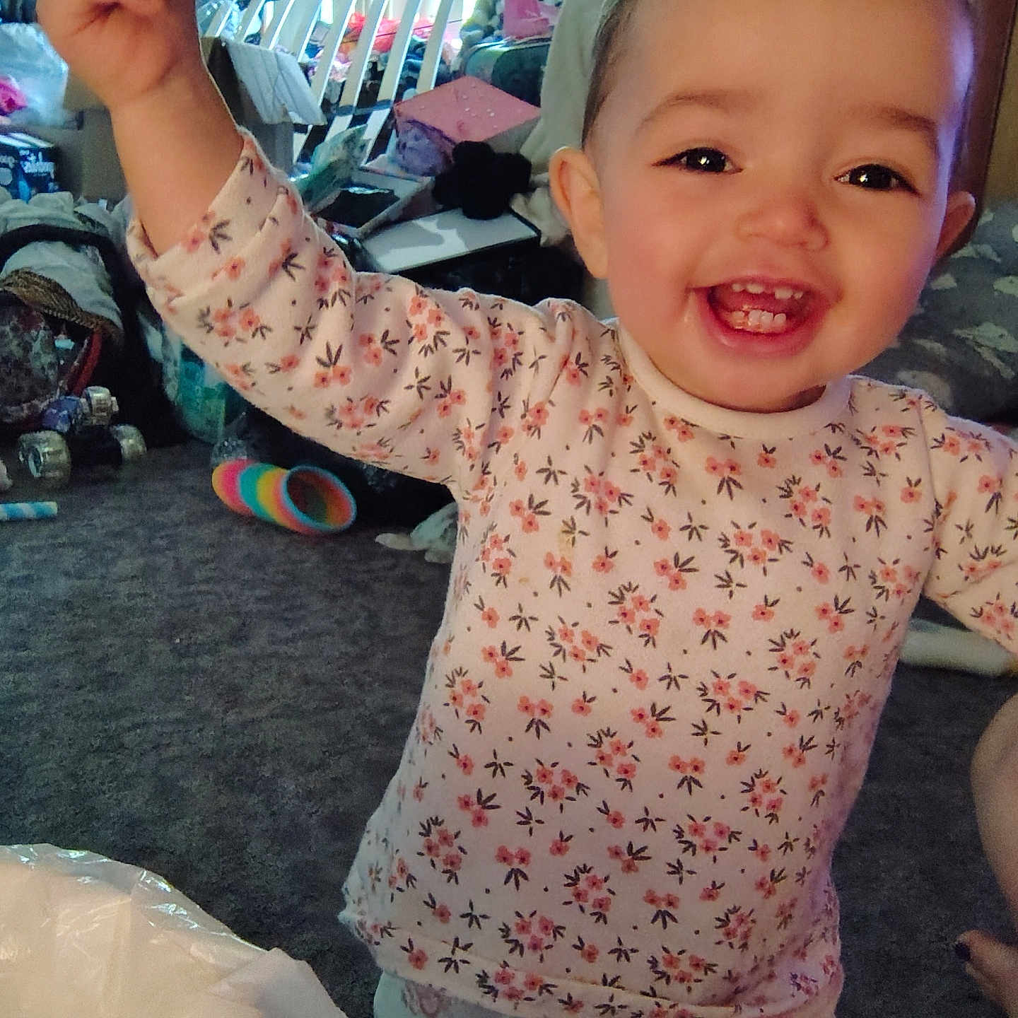 Tehleyiah is registered to the contest to win money with this photo: baby, carpet, child, clutter, curtains, face, floral_clothing, furniture, happy, head, indoors, living_room, pants, person, raised_arm, smiling, socks, toddler, toy, window_blinds