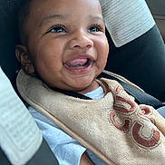 Kyrie is registered to the contest to win money with this photo: baby, smiling, car_seat, bib, happy, child, infant, portrait, clothing, seatbelt, face, cute, young, skin, person, closeup, expression, joyful, indoors, comfort