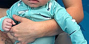 Kevan participe au concours pour gagner de l'argent avec cette photo : adult, arms, baby, blue, child, closeup, curious, expression, holding, infant, outdoor, person, pool, skin, splash, summer, swimming, swimsuit, water, whale_pattern