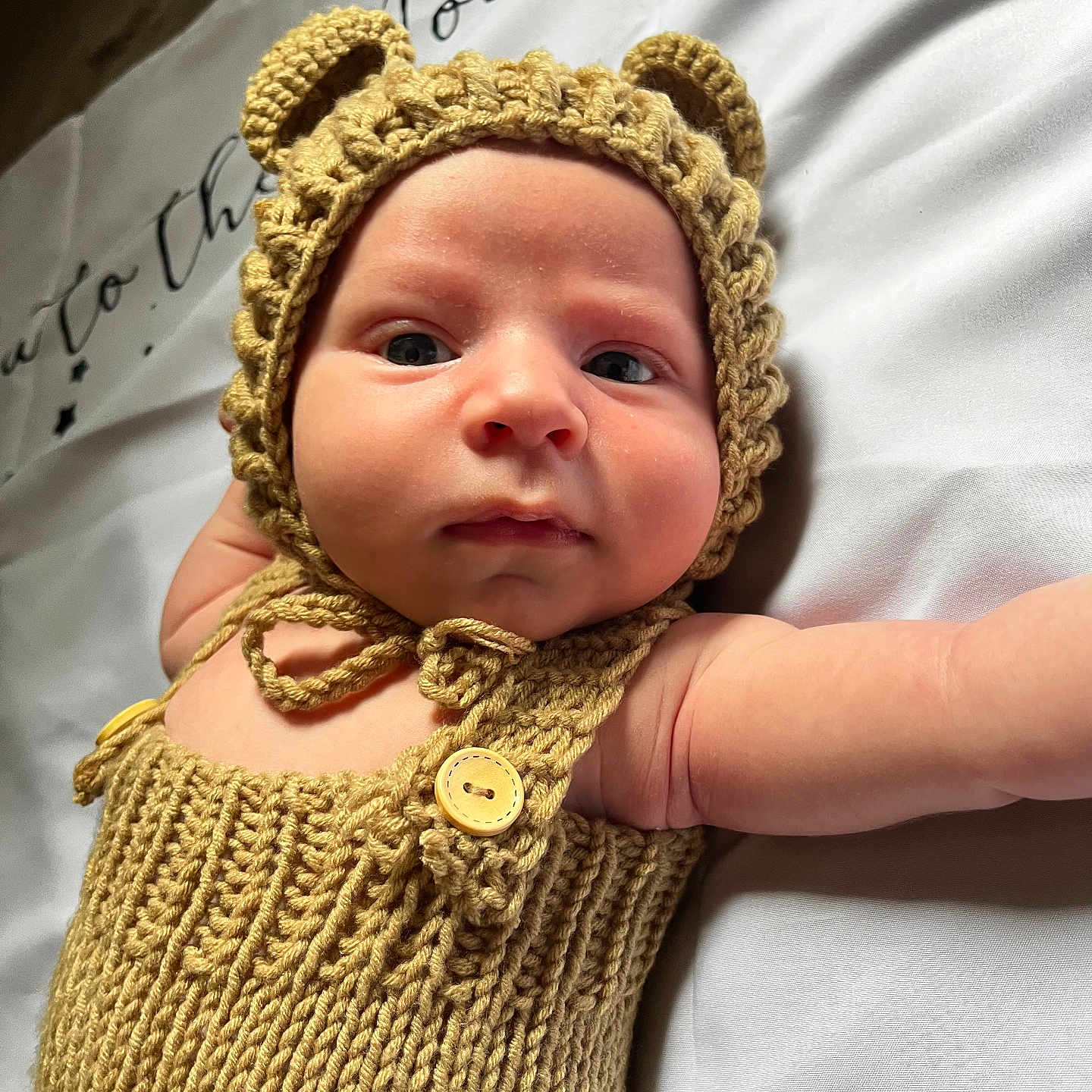 Kevan a rejoint le concours — aidez-le/la à gagner de superbes lots ! adorable, arm, baby, button, child, closeup, cozy, cute, expression, face, handmade, headwear, infant, knitted_hat, knitted_outfit, lying_down, newborn, portrait, soft_light, white_background