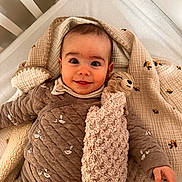 Hugo participe au concours pour gagner de l'argent avec cette photo : baby, child, crib, blanket, stuffed_animal, pajamas, smile, face, cozy, cute, indoor, bed, soft_toy, person, infant, sleepwear, head, hand, comfort, cute_expression