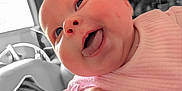 Ivy is registered to the contest to win money with this photo: baby, face, tongue, pink_clothing, closeup, infant, child, happy, cute, skin, hand, expression, indoors, portrait, head, chubby_cheeks, soft_light, smile, person, candid