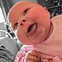 baby, face, tongue, pink_clothing, closeup, infant, child, happy, cute, skin, hand, expression, indoors, portrait, head, chubby_cheeks, soft_light, smile, person, candid