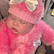 Ivy is registered to the contest to win money with this photo: baby, sleeping, pink, hat, bow, knitwear, hand, couch, indoor, child, person, cute, soft, warm, cozy, fuzzy, clothing, infant, rest, comfort