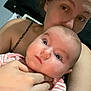 Amara is registered to the contest to win money with this photo: baby, woman, face, close_up, indoor, holding, kiss, person, child, skin, hand, portrait, expression, infant, caring, love, striped_clothing, human, family, affection