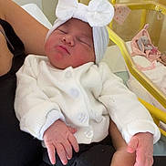 Layna a rejoint le concours — aidez-le/la à gagner de superbes lots ! arms, baby, black_pants, blanket, bow, bunny_toy, crib, cute, hand, hospital, indoor, infant, newborn, person, sleeping, soft_lighting, stuffed_toy, white_cardigan, white_headband, yellow_crib