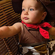 Nathan participe au concours pour gagner de l'argent avec cette photo : toddler, child, cowboy, hat, red_scarf, blue_eyes, wicker_chair, brown_clothing, costume, portrait, cute, indoor, baby, face, person, sitting, curious, expression, closeup, arm