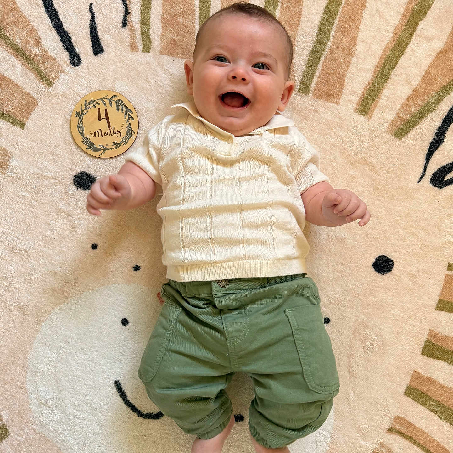 Liam participe au concours pour gagner de l'argent avec cette photo : baby, baby_girl_or_boy, child, clothing, cream_sweater, cute, cute_rug, face, four_months, green_pants, happy, indoors, infant, joyful, lion_design, lying_down, playful, portrait, smile, soft_texture