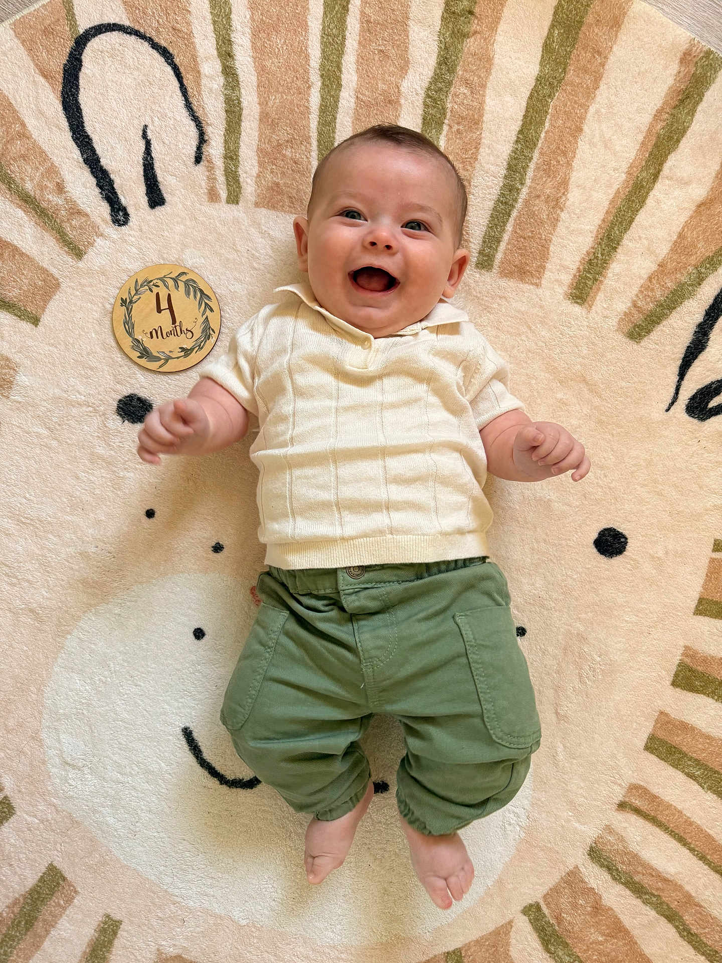 Liam participe au concours pour gagner de l'argent avec cette photo : baby, baby_girl_or_boy, child, clothing, cream_sweater, cute, cute_rug, face, four_months, green_pants, happy, indoors, infant, joyful, lion_design, lying_down, playful, portrait, smile, soft_texture