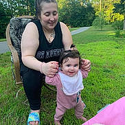 Annaliese is registered to the contest to win money with this photo: baby, bib, chair, child, footwear, grass, greenery, happy, holding_hands, nature, onesie, outdoor, parenting, person, road, smile, sunlight, tattoo, tree, woman