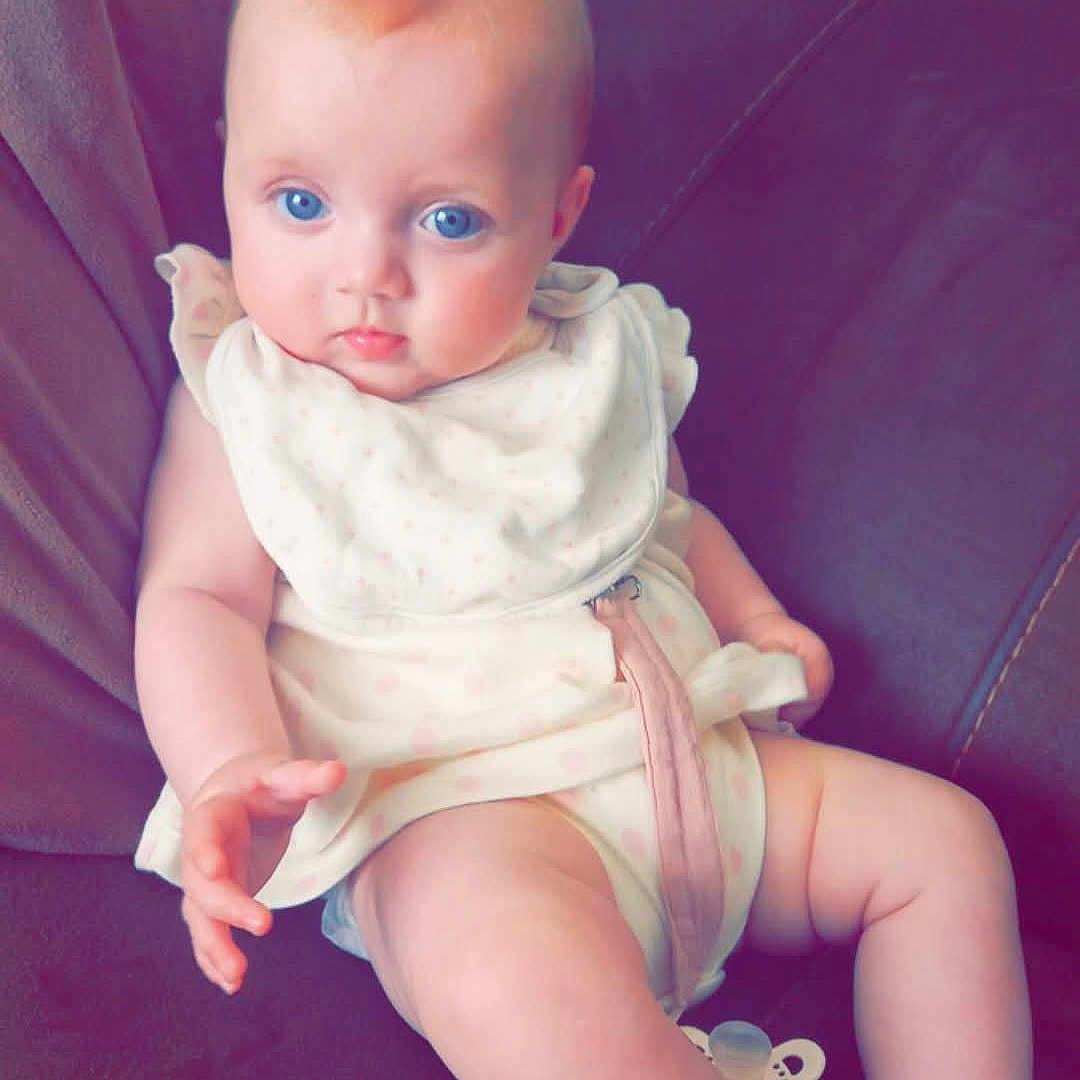 Araia-Louise joined the competition — help win amazing prizes! baby, bib, blue_eyes, child, clothing, comfort, couch, cute, furniture, home, indoor, infant, pacifier, person, plump, portrait, relaxed, sitting, skin, young_child