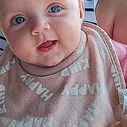 Araia-Louise is registered to the contest to win money with this photo: baby, infant, blue_eyes, bib, smiling, drool, close_up, person, child, cute, happy, clothing, striped_shirt, holding, skin, face, mouth_open, hand, indoor, portrait