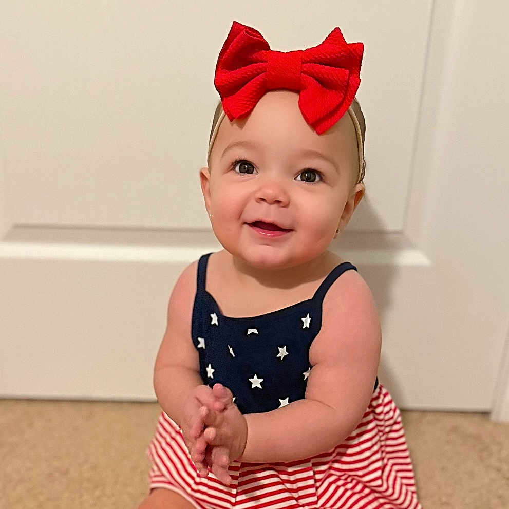 Emery joined the competition — help win amazing prizes! accessories, baby, bowtie, clothing, dress, face, formalwear, happy, head, headband, jewelry, necklace, pants, person, photography, portrait, sitting, smile, t_shirt, tie