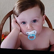 Myles joined the competition — help win amazing prizes! baby, blue_eyes, chair, child, closeup, curious, expression, face, hand_on_face, head, indoor, looking, pacifier, portrait, resting, seated, skin, toddler, wooden_chair, young_child
