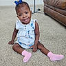 toddler, child, smiling, sitting, carpet, living_room, dress, pink_socks, blue_bow, happy, indoor, furniture, leather_couch, person, cute, young_child, portrait, floor, home, casual