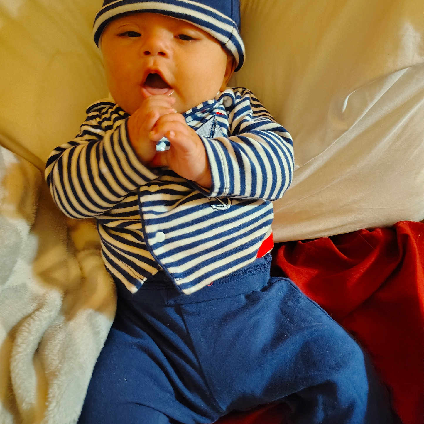 Elijah is registered to the contest to win money with this photo: baby, beanie, bodypart, bonnet, cap, clothing, couch, face, finger, furniture, hand, hat, head, knitwear, pants, person, photography, portrait, sitting, sweater