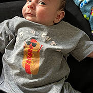 Lazarus joined the competition — help win amazing prizes! baby, infant, tshirt, clothing, hotdog, cartoon, face, expression, lying_down, blanket, colorful, cute, child, person, casual, indoor, portrait, skin, head, eyes