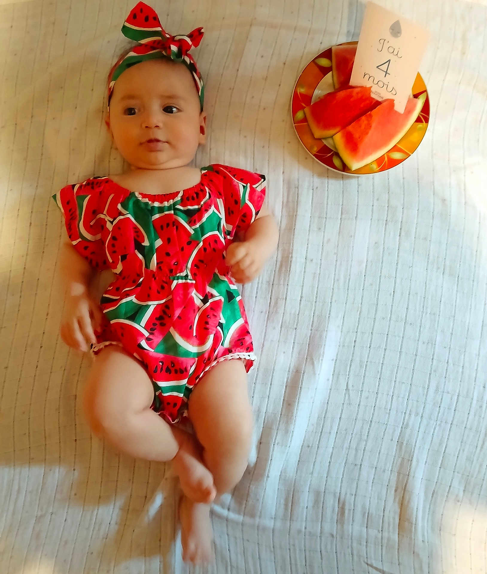 Melissa a rejoint le concours — aidez-le/la à gagner de superbes lots ! baby, infant, watermelon_outfit, headband, plate, watermelon_slices, card, blanket, striped, lying_down, cute, milestone, four_months, child, indoors, person, summer, fruit, food, clothing