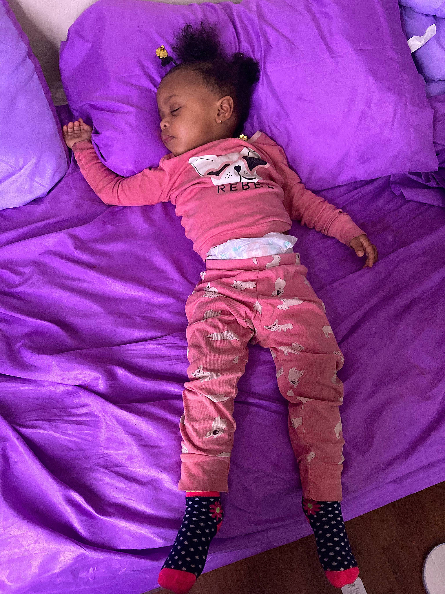 Patience is registered to the contest to win money with this photo: baby, baby_toddler_clothing, bedding, child, comfort, fun, happy, linens, magenta, pattern, person, pillow, pink, purple, room, sleeve, t_shirt, textile, throw_pillow, toddler