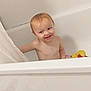 toddler, child, bath, bathtub, shower_curtain, rubber_duck, smile, wet_hair, bathroom, water, play, fun, skin, happy, young_child, person, indoors, cleaning, cute, joy
