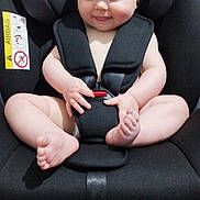 Rae is registered to the contest to win money with this photo: baby, infant, car_seat, child, smile, skin, seatbelt, safety_harness, indoors, cute, chubby, hands, feet, car_safety, straps, expression, young_child, seat, person, car_seat_baby
