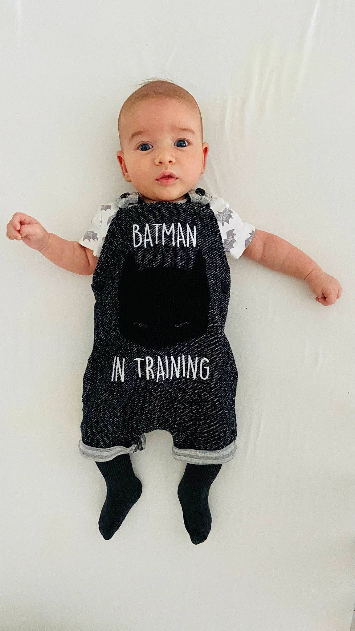 Aidan is registered to the contest to win money with this photo: arm, baby_toddler_clothing, eye, face, finger, gesture, grey, hand, head, headgear, human_body, joint, leg, neck, outerwear, person, shoulder, sleeve, standing, t_shirt