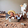 Eithan is registered to the contest to win money with this photo: baby, child, hat, straw_hat, metal_tub, overalls, smiling, indoor, cow_plush, toy_cow, farm_theme, decor, floor, rustic, person, cute, happy, sitting, playful, portrait