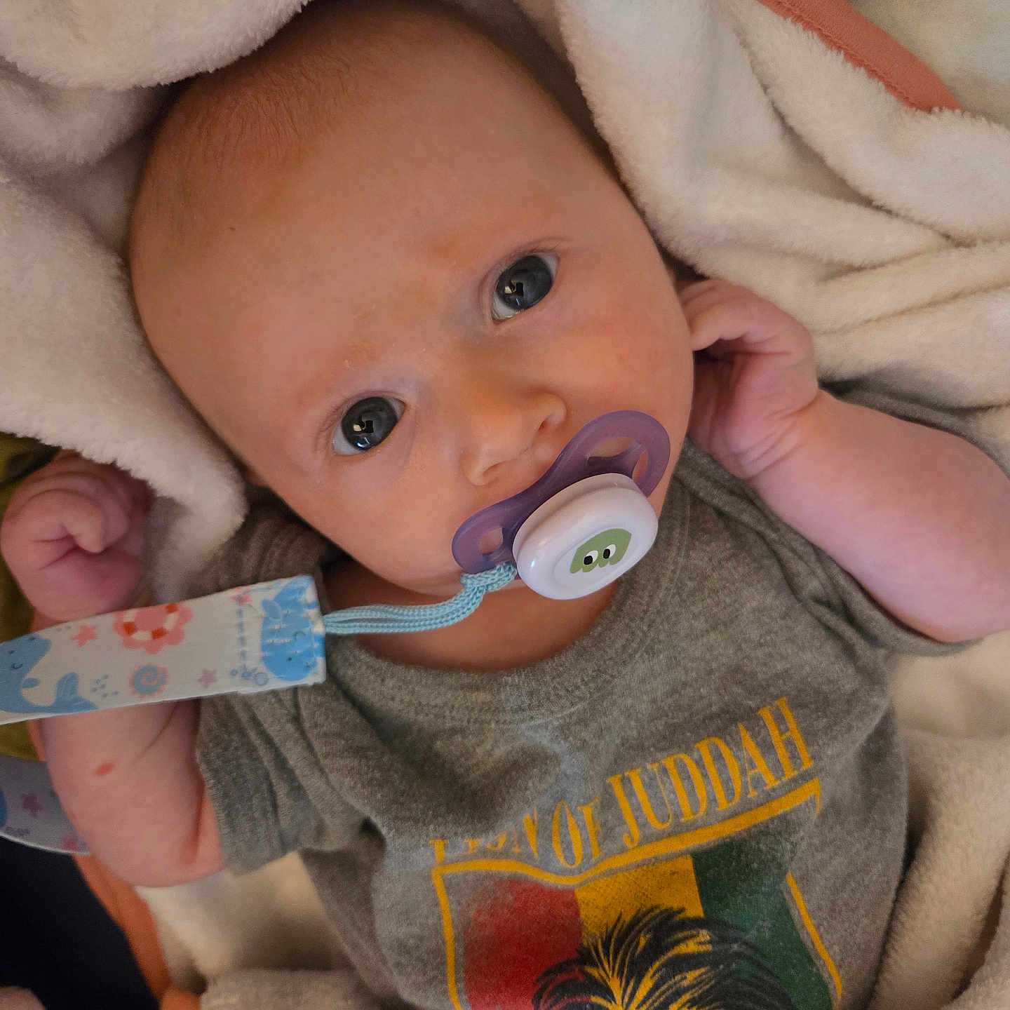 Lyv participe au concours pour gagner de l'argent avec cette photo : baby, blanket, child, clothing, comfort, cute, expression, eyes, face, hand, indoor, infant, lying_down, newborn, pacifier, portrait, resting, shirt, soft_texture, young