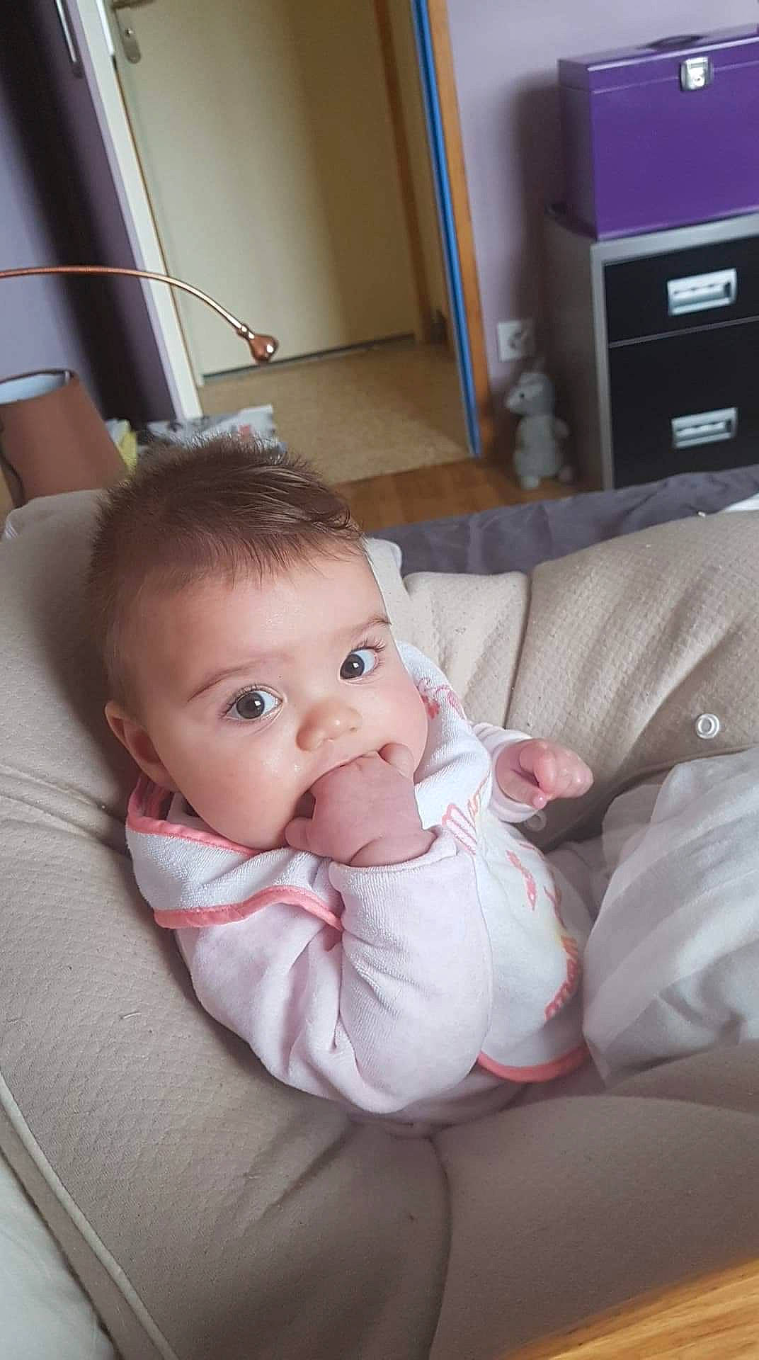 Soline a rejoint le concours — aidez-le/la à gagner de superbes lots ! baby_products, bed, cheek, child, day, finger, furniture, girl, hand, infant, leg, nose, person, product, sitting, skin, toddler