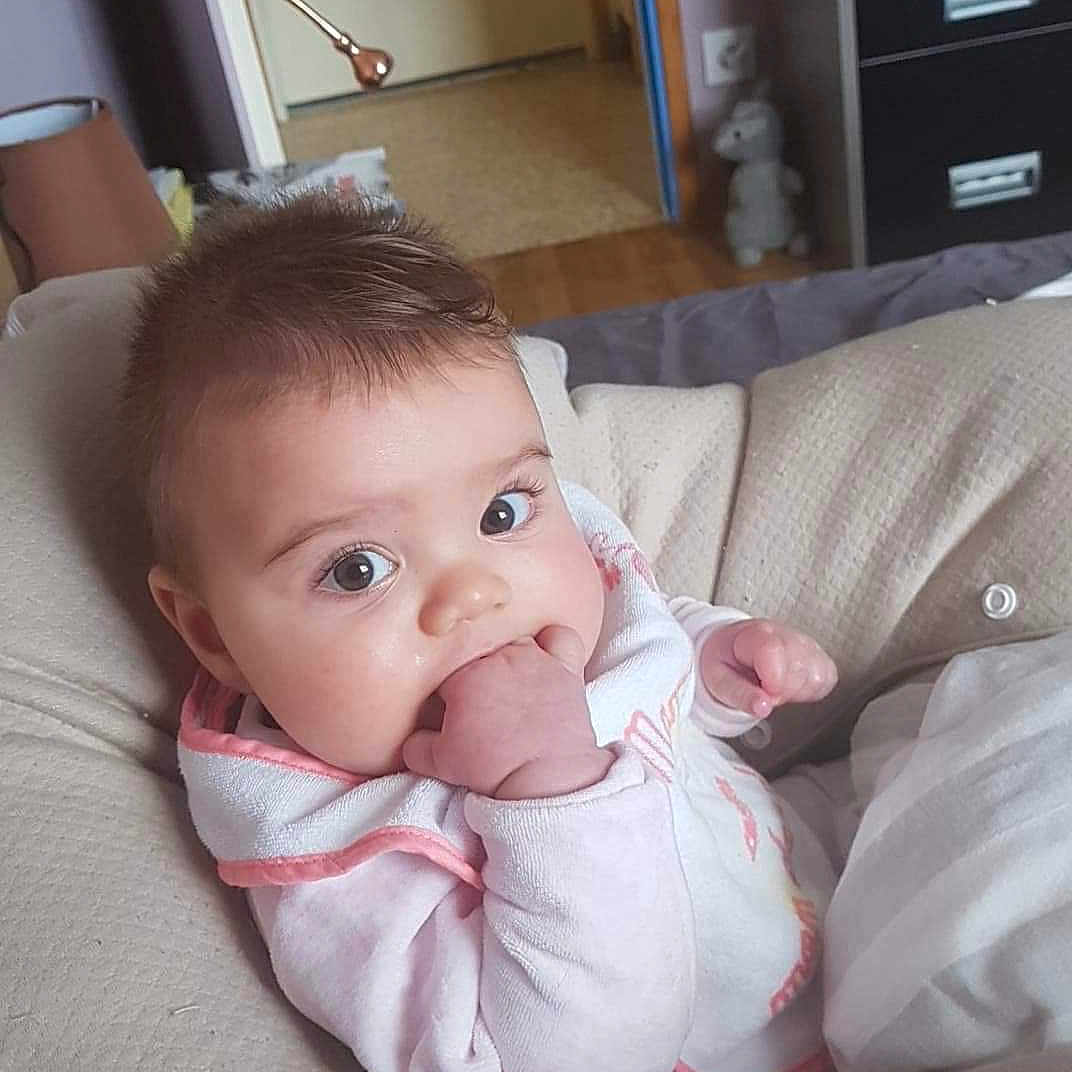 Soline a rejoint le concours — aidez-le/la à gagner de superbes lots ! baby_products, bed, cheek, child, day, finger, furniture, girl, hand, infant, leg, nose, person, product, sitting, skin, toddler