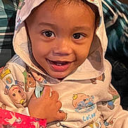 Achilles joined the competition — help win amazing prizes! toddler, child, hoodie, smile, happy, face, hand, clothing, cartoon_print, indoor, portrait, young_child, cute, person, black_hair, casual_wear, sitting, bright_eyes, baby, playful