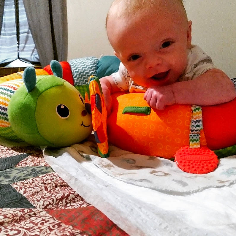 Duncan joined the competition — help win amazing prizes! baby, baby_playing_with_toys, baby_products, baby_toddler_clothing, cheek, child, comfort, face, facial_expression, finger, happy, head, mouth, orange, organ, person, skin, smile, toddler, toy