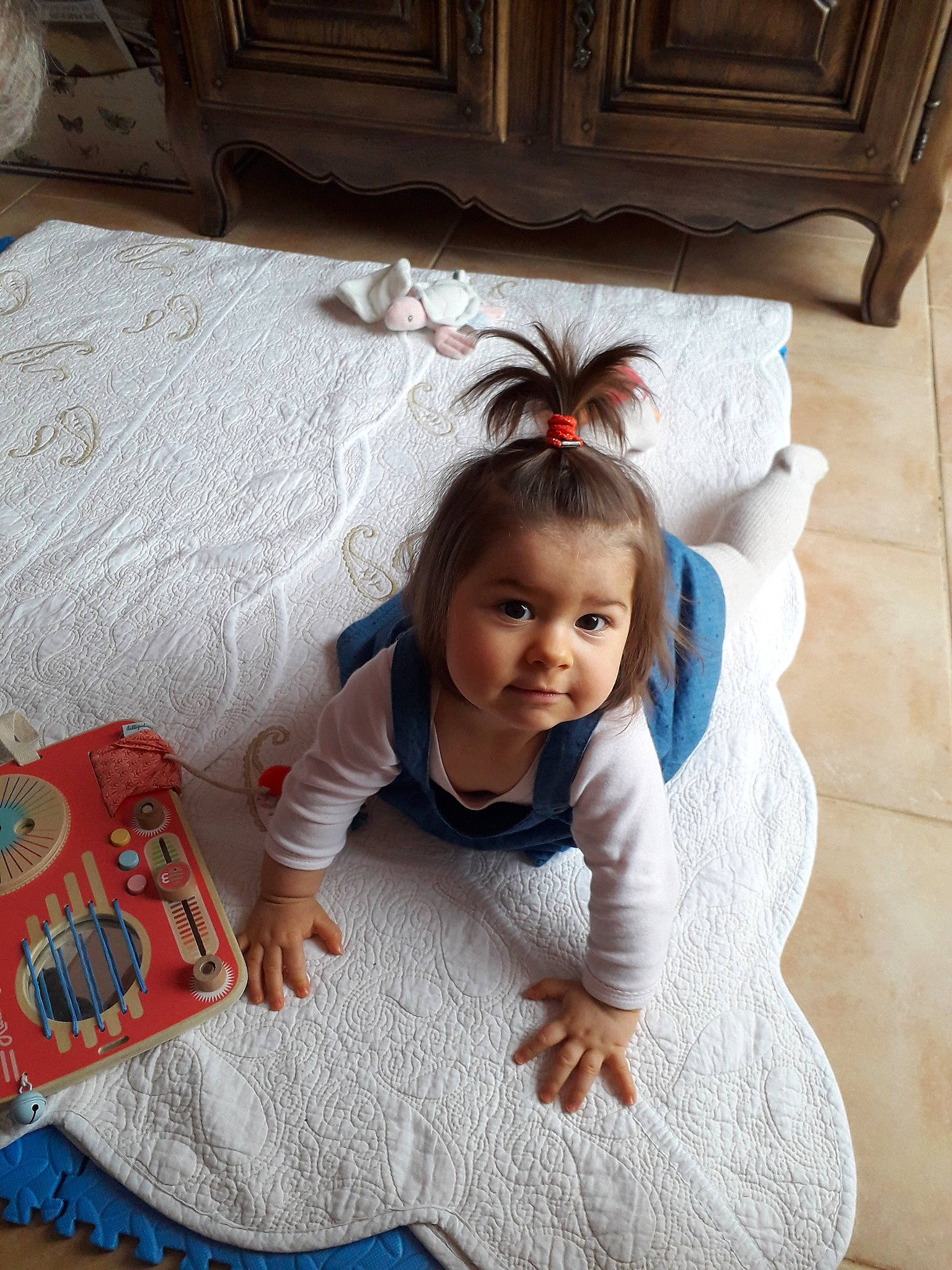 Lucile participe au concours pour gagner de l'argent avec cette photo : baby_toddler_clothing, bedding, child, comfort, design, floor, flooring, fun, happy, hardwood, leisure, linens, person, product, sitting, smile, textile, toddler, white, window