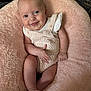 Nyla is registered to the contest to win money with this photo: baby, infant, smile, tongue, knitwear, cushion, pink, soft_texture, comfort, cute, child, portrait, happy, skin, face, hand, foot, sitting, indoors, cozy