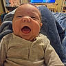 Jett joined the competition — help win amazing prizes! baby, infant, child, portrait, close_up, face, open_mouth, wide_eyes, indoors, home, knitwear, sweater, cream_clothing, sitting, blanket, jeans, television, stuffed_toys, cozy, expression