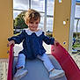 Amalya participe au concours pour gagner de l'argent avec cette photo : toddler, child, slide, playground, outdoor, daylight, clothing, shoes, fence, sky, tree, grass, metal, plastic, play_equipment, person, young_child, fun, recreation, smile