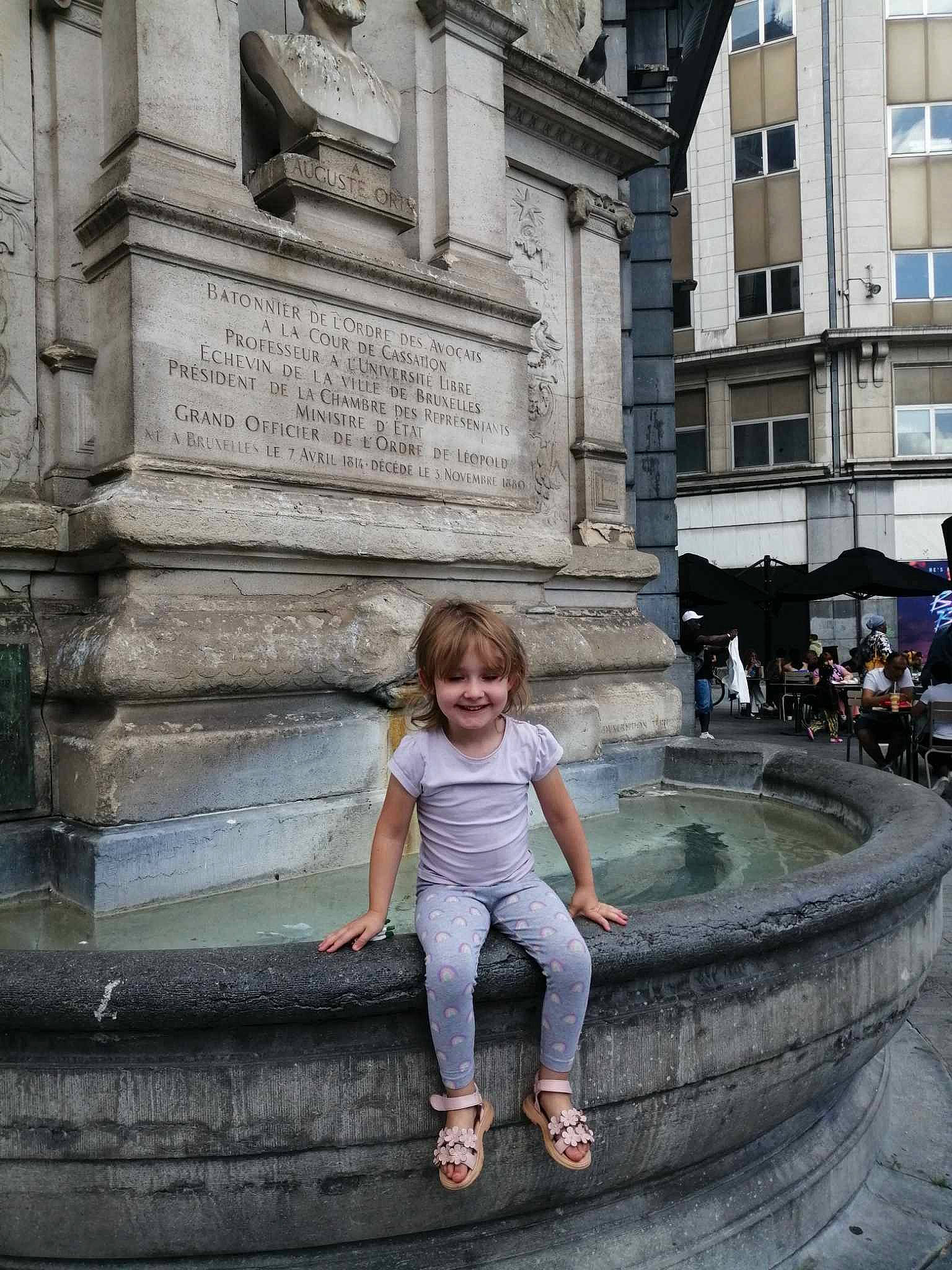Laura participe au concours pour gagner de l'argent avec cette photo : beauty, building, city, font, fountain, joy, landmark, leisure, morning, person, public_space, road, road_surface, smile, standing, street, temple, toddler, travel, water