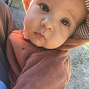 Joseph joined the competition — help win amazing prizes! baby, child, face, hood, brown_clothing, outdoor, sunlight, curious_expression, closeup, person, cute, infant, young_child, fuzzy_outfit, portrait, warm_clothing, car, grass, daylight, nature