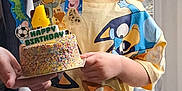 Jensen joined the competition — help win amazing prizes! child, birthday_cake, sprinkles, cartoon_toppers, bluey, tshirt, pants, indoor, window, curtain, celebration, party, cake, holding, person, smile, happy, four_years_old, home, young_child