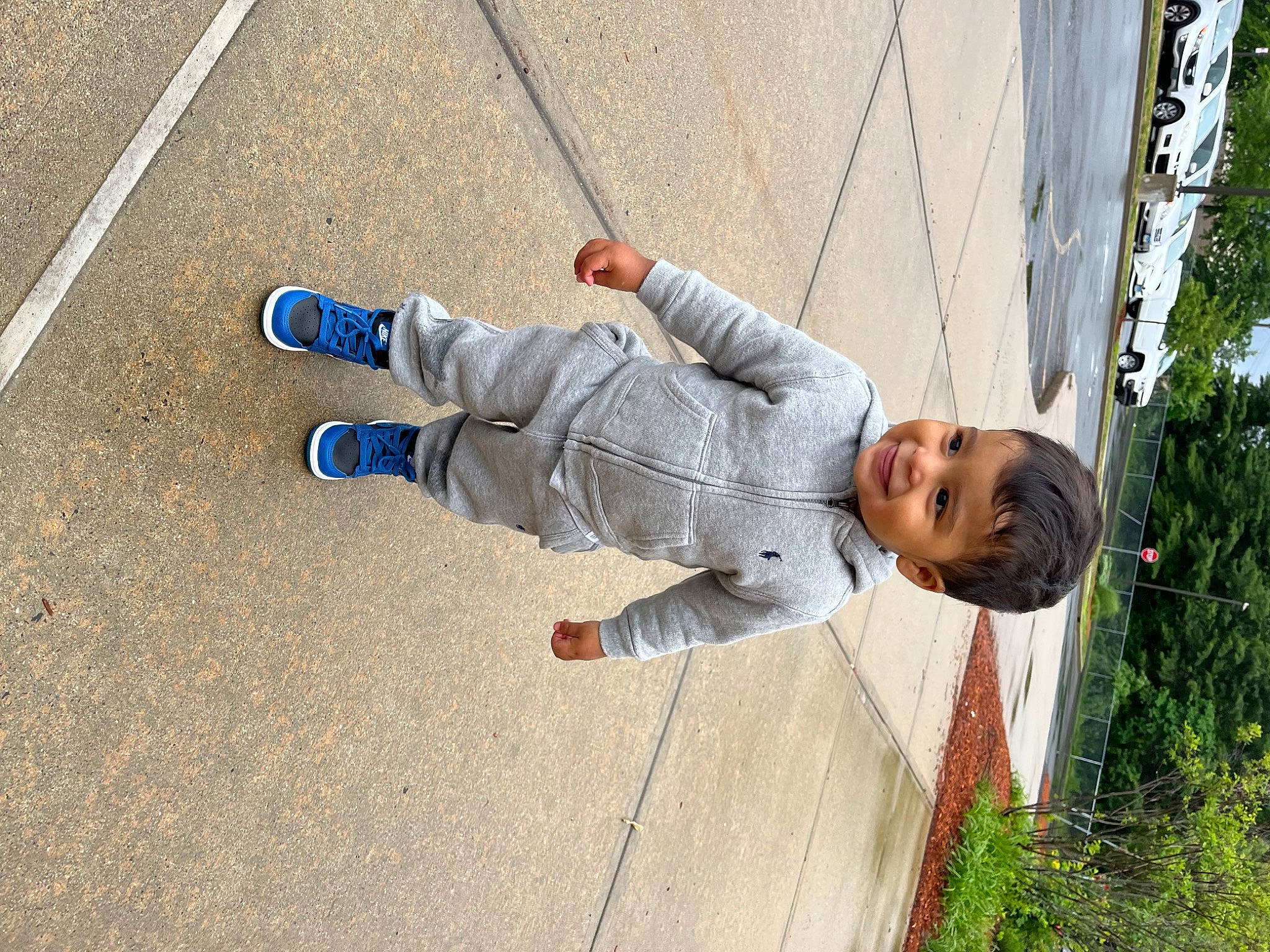 Luis is registered to the contest to win money with this photo: asphalt, denim, electric_blue, fun, human_leg, jeans, joy, leg, leisure, outdoor_shoe, person, plant, recreation, road_surface, shoe, sidewalk, smile, sneakers, street_fashion, toddler