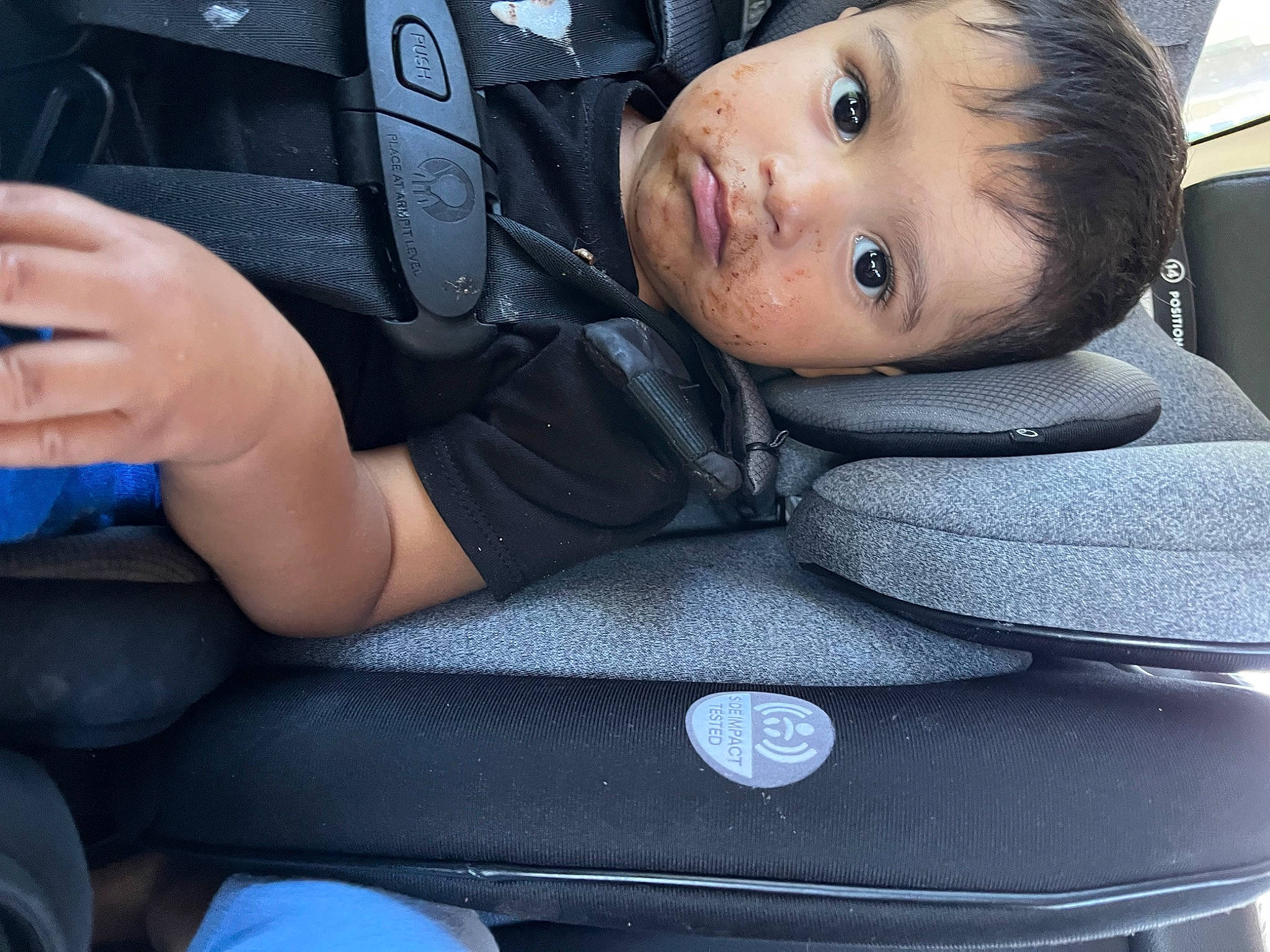 Luis is registered to the contest to win money with this photo: auto_part, automotive_design, black, blue, blurred, car_seat, car_seat_cover, comfort, finger, gesture, hand, head_restraint, material_property, motor_vehicle, person, personal_luxury_car, product, steering_part, steering_wheel, toddler