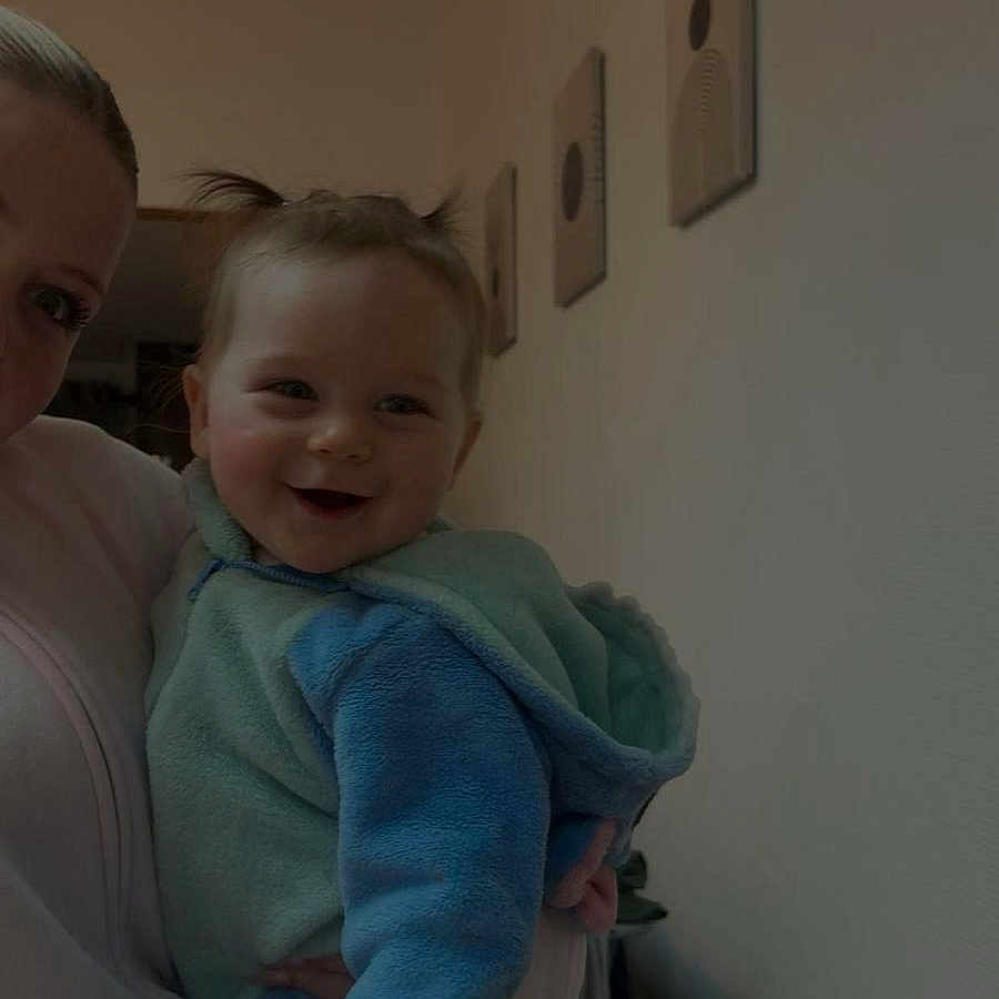 Sky a rejoint le concours — aidez-le/la à gagner de superbes lots ! baby, child, smiling, pigtails, fleece, pajamas, adult, person, indoor, wall, painting, home, holding, happy, cute, face, portrait, cozy, clothing, infant