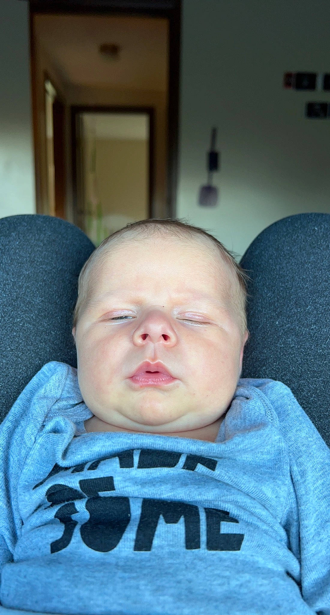 Winston is registered to the contest to win money with this photo: azure, baby, baby_toddler_clothing, cheek, child, chin, comfort, electric_blue, eyelash, forehead, jaw, linens, mouth, neck, nose, person, sitting, skin, sleeve, t_shirt