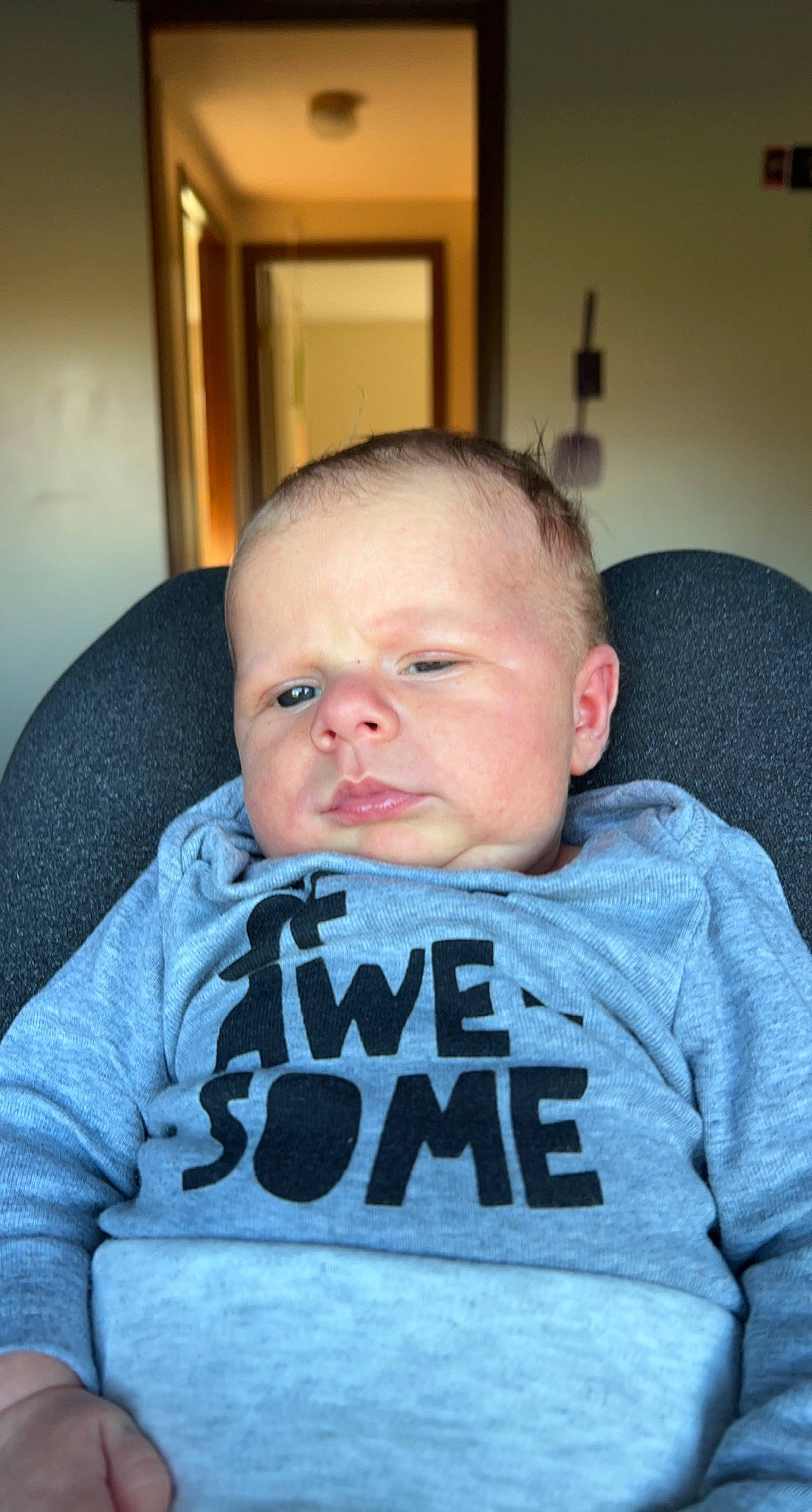 Winston is registered to the contest to win money with this photo: baby, baby_toddler_clothing, beard, chair, cheek, child, chin, comfort, cool, facial_hair, fun, happy, mouth, no_expression, nose, person, room, sitting, sleeve, t_shirt